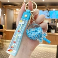 Blue sunshine unicorn keychain featuring a floating flower acrylic ball and silicone strap - Flower Lollipop - Blue