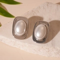 Macro view of geometric silver earrings with white faux pearl and wide metallic border - Silver Pin - Silver Pearl Geometric Stud Earrings