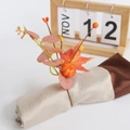 Harvest napkin ring with pumpkin, maple leaf, and berries on a beige cloth napkin - Orange Eucalyptus Maple Leaf Pumpkin Napkin Ring