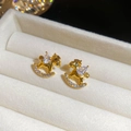 Dettaglio macro di orecchini a cavallo a dondolo dorati con zirconi su velluto beige - Stile Cavallo a Dondolo / Oro