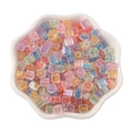 Iridescent 5mm square glass beads with colorful cores for DIY jewelry in a white dish - Macaron Series