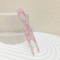 Dettaglio macro della forcina a U in acetato rosa marmorizzato per acconciature eleganti - Rosa Chiaro Grande