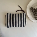 Detail of striped canvas pouch with white zipper and simple wish woven label - Striped
