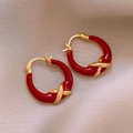 Minimalistische rote Herz-Ohrringe in Gold mit Twist-Design auf beigem Stoff - 94# Ohrenschnalle - Rot-Gold Kreuz-Design Reif