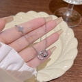 Collana in titanio argento con anelli intrecciati e ciondolo a stella su modella - Stile Stella a Doppio Anello Intrecciato (X771) / Argento