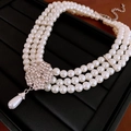 Macro detail of three-layer pearl necklace with rhinestone flower and teardrop pendant - Three-Layer Stacked Flower Decor / White