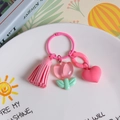 Pink resin tulip keychain with tassel and heart pendant on a white decorative plate - Transparent Pink Tulip