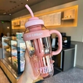Pink high-capacity plastic straw cup with handle and stirrer in a cafe setting - Belly Cup / Pink
