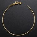 Elegant gold plated brass snake chain bracelet with adjustable lobster clasp on black background - Bracelet / Gold