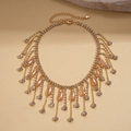 Detailopname van gouden kwastjesketting met champagnekristallen en witte strasstenen - Goud / Champagne