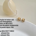 Polished gold oval stud earrings shown on a white ceramic plate with French text decor - Gold