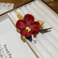 Dettaglio del fermaglio per capelli con fiore rosso, foglie dorate e perle pendenti - Fermaglio a becco d'anatra in metallo cavo con fiore rosso fatto a mano / Oro-Rosso