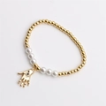 Pulsera bohemia de cuentas doradas con perlas blancas y amuleto mano de Fátima en fondo blanco - Dorado/Perla Blanca