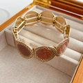 Dettaglio di bracciale elastico vintage dorato con ciondoli ritratto rosa-marrone sbalzato - Decorazione a Rilievo Rosa Marrone / Oro-Rosa