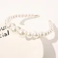 Macro detail of elegant gradient white pearls on a gold metal headband base - Three Large Pearls