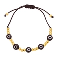 Detail of bohemian evil eye woven bracelet with gold beads and adjustable brown cord - Black