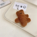 Dettaglio di un portachiavi a forma di orsetto di peluche marrone con catena - Orso bruno