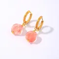 Macro detail of geometric gold hoop earrings with faceted pink natural stone pendants - Pink