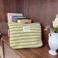 Yellow and blue striped plush cosmetic bag with colorful label on cozy wooden shelf - Yellow Stripe