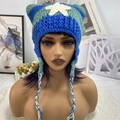 Detailed knit texture of a cat ear beanie with star patch and braided tassels - Blue Green Braids