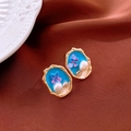 Detail of gold-tone butterfly earrings with blue resin fill and pearl accents on brown satin - Purple Butterfly Pearl Glaze Style