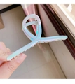 Detail of pearlescent white twisted hair claw clip with visible metal spring mechanism - Mermaid Cross