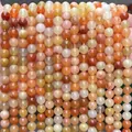 Hand holding natural orange and red agate beads for DIY jewelry making and crafting - Natural Golden Silk Jade 4mm (Approx. 90pcs) Strand