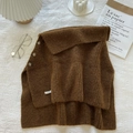 Detail of brown ribbed knit shawl featuring three buttons and brand label on fabric - Brown
