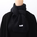 Detailed close-up of a black knit scarf featuring a minimalist white FEIDG label - Black