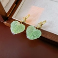 Dettaglio di orecchini a cuore placcati in oro 14k con zircone verde su portagioie in legno - Stile Clip per Orecchio Strutturato a Cuore / 6# Verde (Clip per Orecchio Placcato Oro Vero)