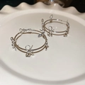 Zilveren oorringen met strikjes en vlindermotieven op een wit keramisch schaaltje - 925 sterling zilveren oorbelstift - Zilver - Strikje