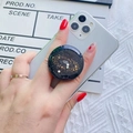 Round glittery starry sky phone grip with golden stars on a white smartphone - Black Base Galaxy
