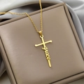 Detailed view of a gold cross necklace with grace engraving on a silk background - Grace / Gold