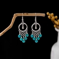 Detail of bohemian turquoise drop earrings with silver metal rings on a wooden branch - E5810-2/Bohemian Woven Net Blue Bead