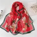 Elegant red silk scarf with large lily flower print and dark green border on white background - Hibiscus Red