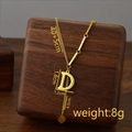 Titanium steel necklace with gold letter D pendant and tassel fringe on a wooden stand - Letter D / Gold