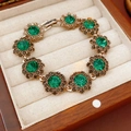 Detailaufnahme eines Vintage-Armbands mit grüner Kristallblume in einer Holzbox - Armband-Grün