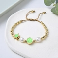Detail of adjustable beaded bracelet with green enamel star, smiley face and freshwater pearls - Green Gold