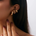 Macro shot of minimalist gold C-shaped ear cuff with smooth polished geometric curves - Multi-Layer Irregular Streamline (03697) / Gold