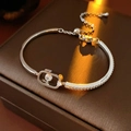 Macro shot of 18k gold plated chain bracelet featuring a dancing zircon in oval pendant - Silver