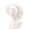 Detail of white satin sleep bonnet with wide elastic headband and side ribbon tie - White