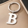 Polished silver metal keychain with uppercase letter B charm on a textured box - Letter B