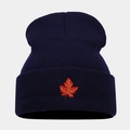 Close-up of red maple leaf embroidery on a dark blue knitted beanie with folded cuff - Navy Blue