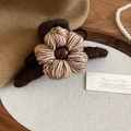 Détail d'une pince à cheveux fleur en tricot avec pétales marrons et centre de couleur crème - Pince À Cheveux Fleur / Marron