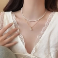 Close-up of double-layered pearl necklace with gold chain and zircon pendant on model - Double Layer Pearl Choker / Gold