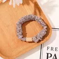Detailed view of high-elasticity hair scrunchie with brown and white wave patterns - Satin Striped Coffee