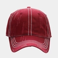 Detalle de gorra de béisbol roja desgastada con costuras blancas en contraste y efecto roto - Burdeos