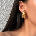 Orecchini pendenti a spirale vuota dorata in acciaio inox indossati su sfondo grigio opaco - Stile Bozzolo a Spirale / Oro