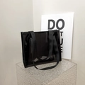 Minimalist black translucent PVC tote bag with wide nylon shoulder straps in modern setting - Black