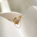 Detalle artístico de anillo dorado con piedra baguette proyectando una sombra de corazón - US 6 / Circonita Cuadrada